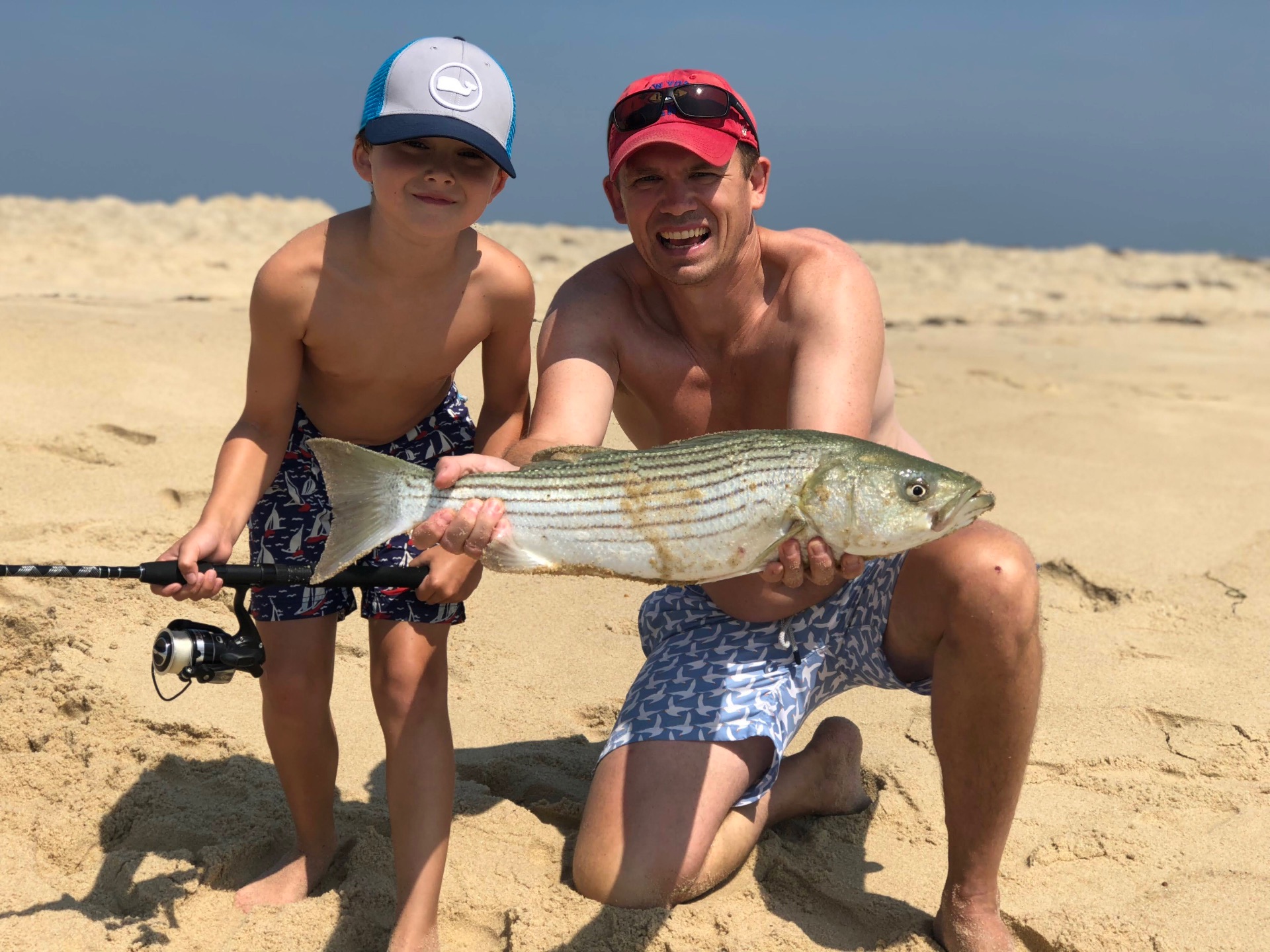 Rob and his son with a striper on the beach