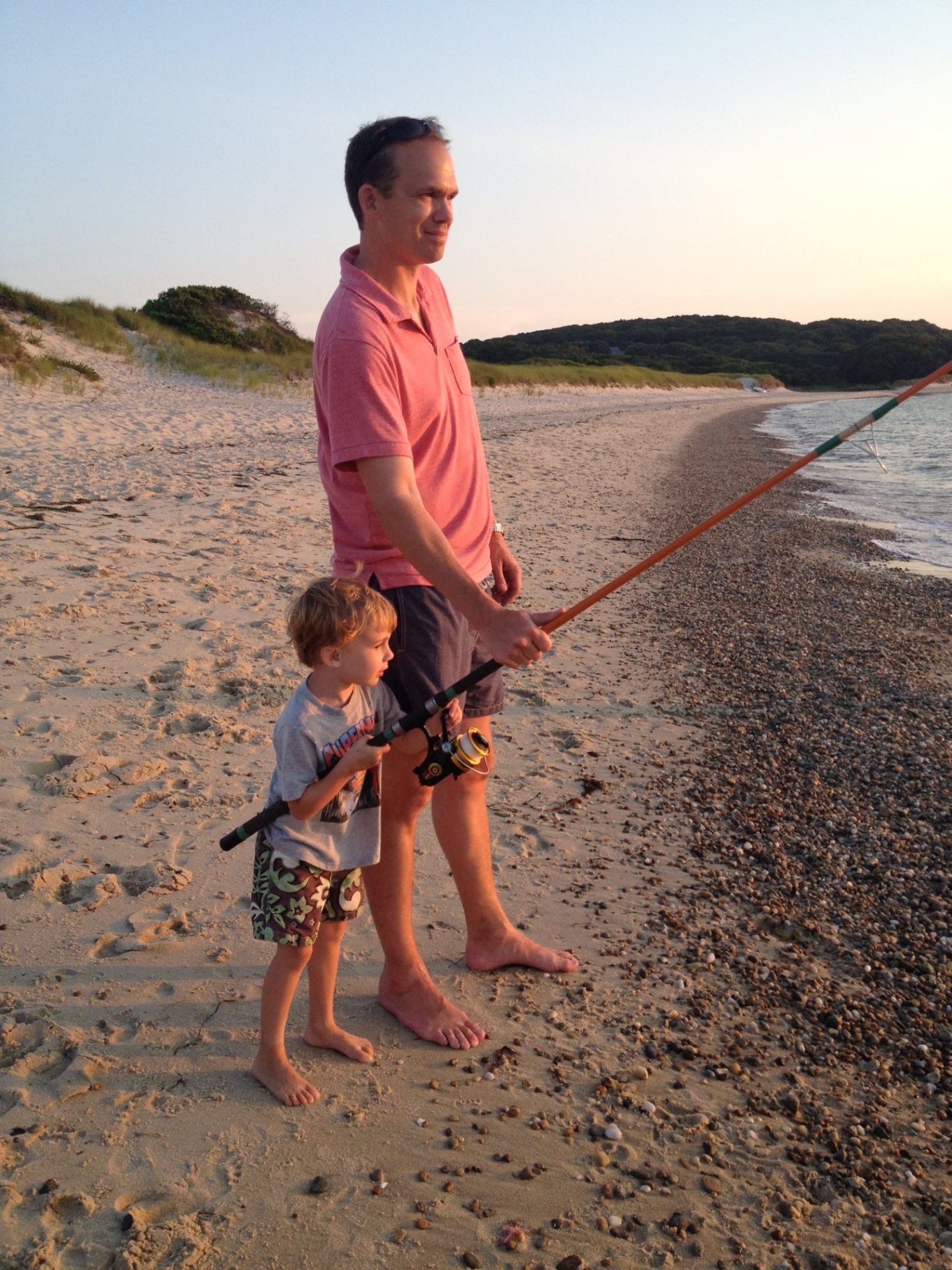 Rob and his young son surfcasting at sunset on the beach